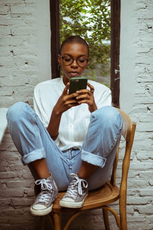 Black women using her phone. Experiencing the negative impacts of technology addiction